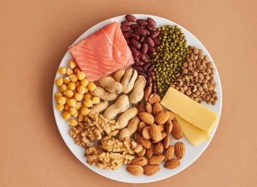 Colorful assortment of proteins and legumes on a white plate, perfect for healthy eating inspiration.